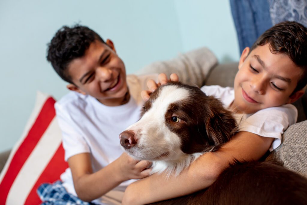 Two kids playing with the dog